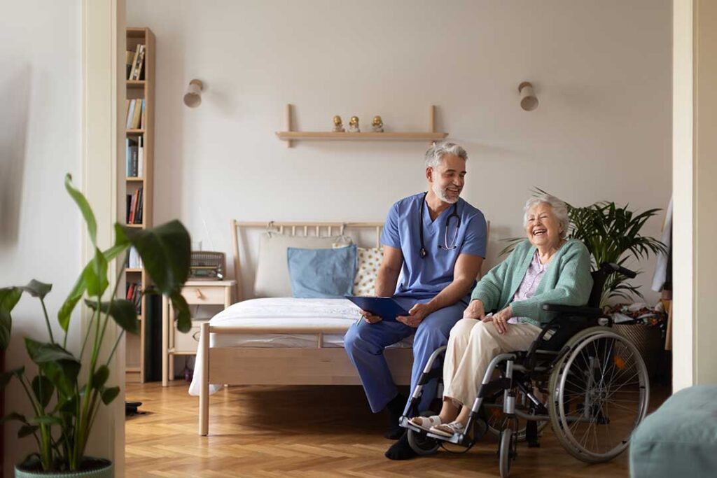 An older adult talking with a family member in a cozy living room, both appearing thoughtful and engaged in conversation.